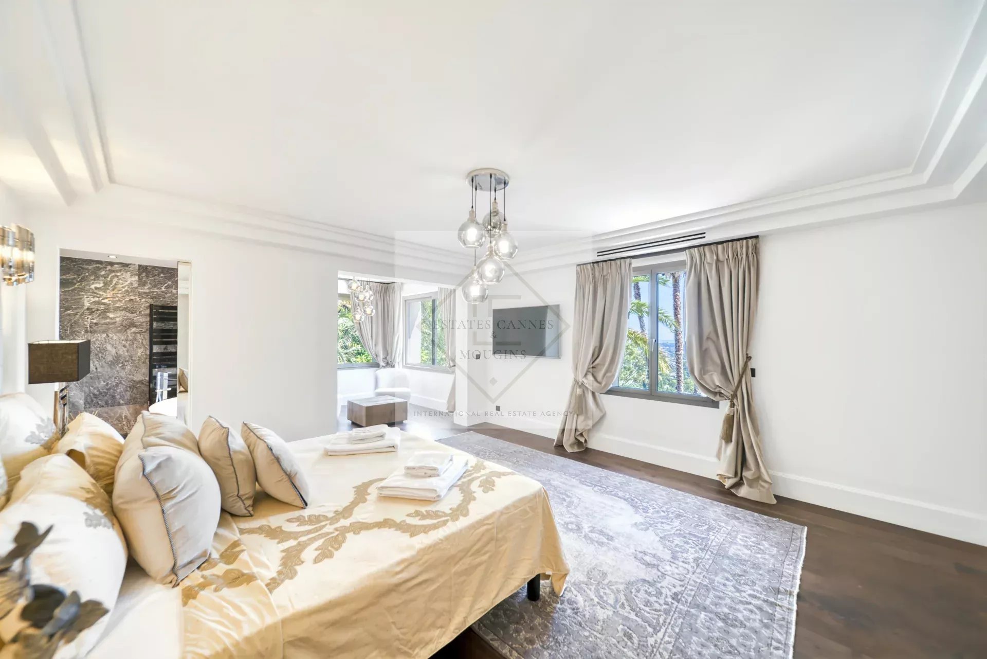 Chambre spacieuse et lumineuse d'une villa à Saint-Paul-de-Vence, avec lit et décoration élégante.