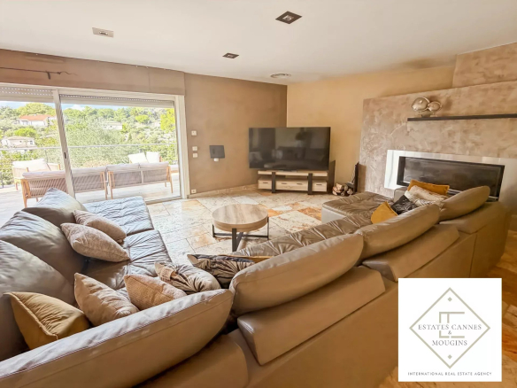 Intérieur d'une villa moderne avec un grand salon et un écran de télévision.