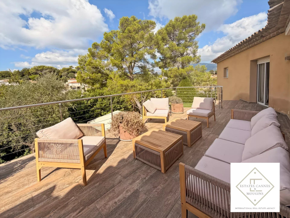Terrasse d'une villa avec mobilier en bois et vue sur la vallée à Roquefort-les-Pins.