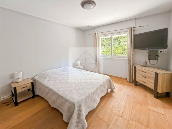 Chambre d'une villa à Roquefort-les-Pins avec lit, meuble et fenêtre.