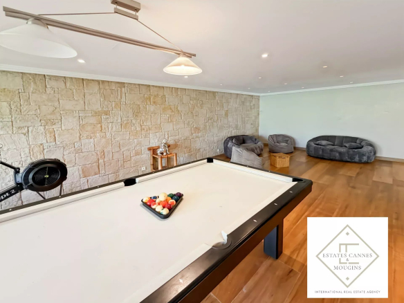 Salle de billard avec table et fauteuils dans une villa à Roquefort-les-Pins.