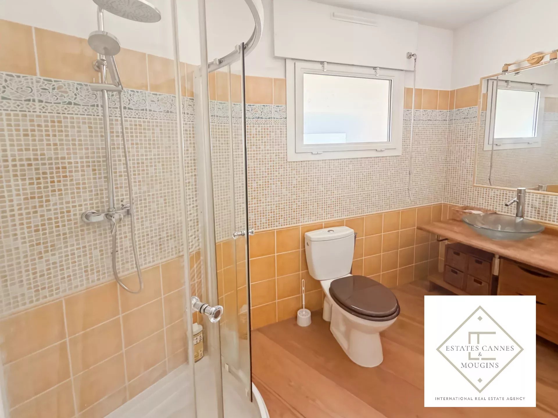 Salle de bain moderne avec douche, toilettes et lavabo en bois.