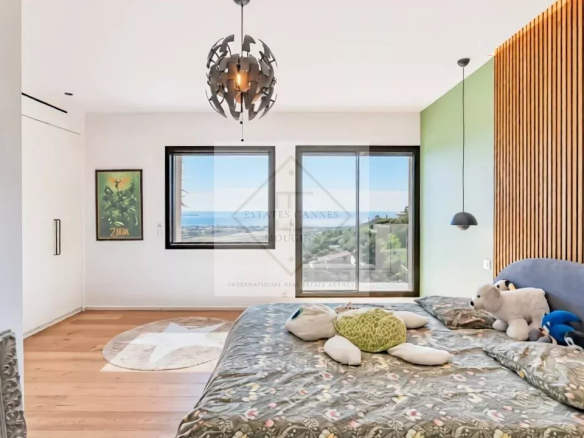 Chambre d'une villa contemporaine avec vue sur la mer, décor moderne et mobilier élégant.