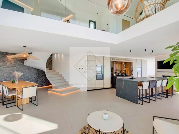 Intérieur d'une villa contemporaine avec salon, salle à manger et cuisine ouverte.