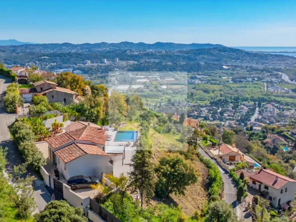Vue aérienne d'une villa contemporaine avec piscine surplombant Mandelieu-la-Napoule et la baie de Cannes.