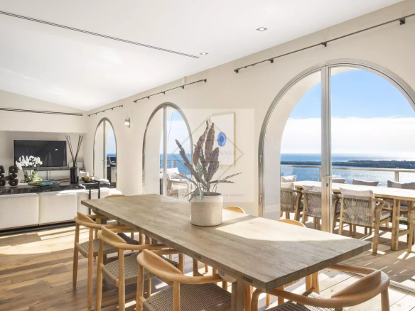 Intérieur d'une villa spacieuse à Cannes avec vue sur la mer et grandes fenêtres.