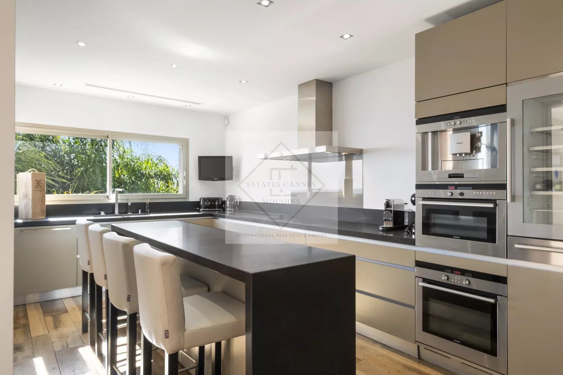 Cuisine moderne et spacieuse d'une villa à Cannes, avec un grand îlot central et des équipements modernes.