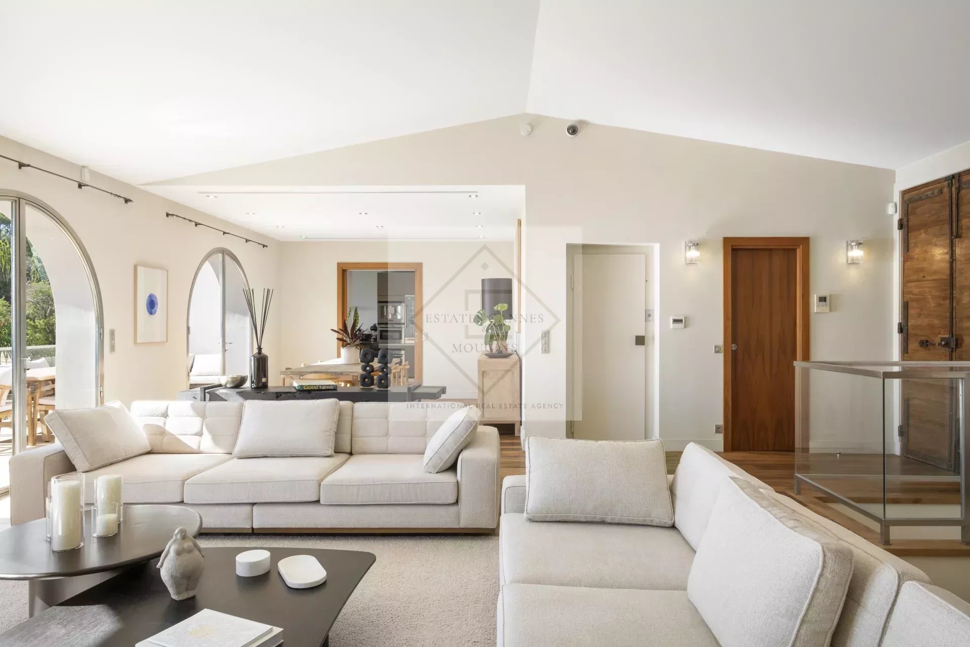 Intérieur d'une villa spacieuse à Cannes, salon lumineux avec canapé et décoration moderne.