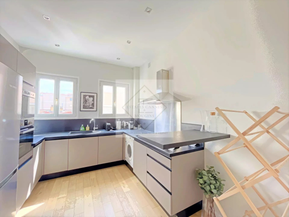 Modern and bright kitchen in an apartment in Cannes, with full equipment and windows.