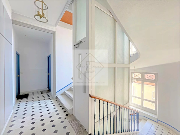 Interior of an apartment in Cannes with a bright hall and a staircase.