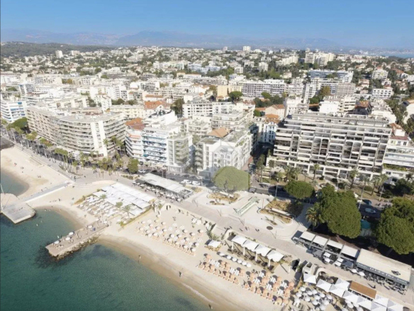 Vue aérienne de Juan-les-Pins avec la mer et des bâtiments en bord de plage.