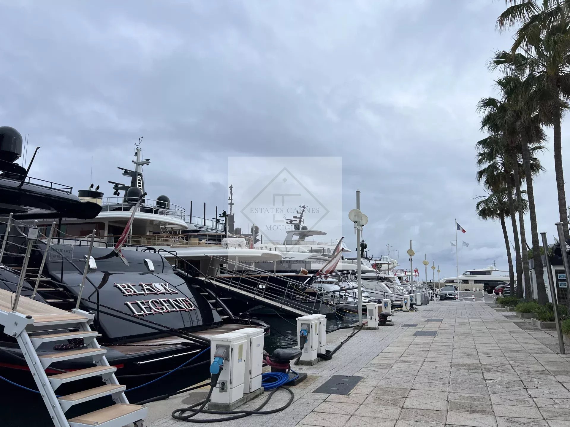 Quai avec yachts à Juan-les-Pins, Antibes, sous un ciel nuageux.
