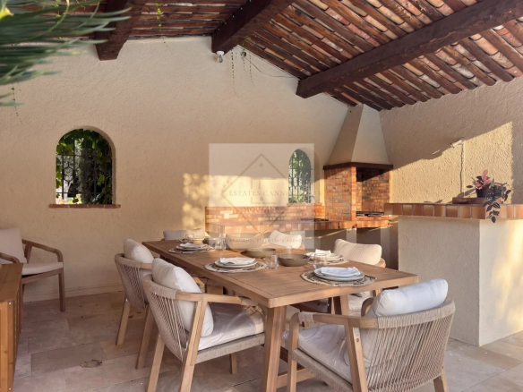 Terrasse extérieure avec table à manger et barbecue dans une villa à Mougins.