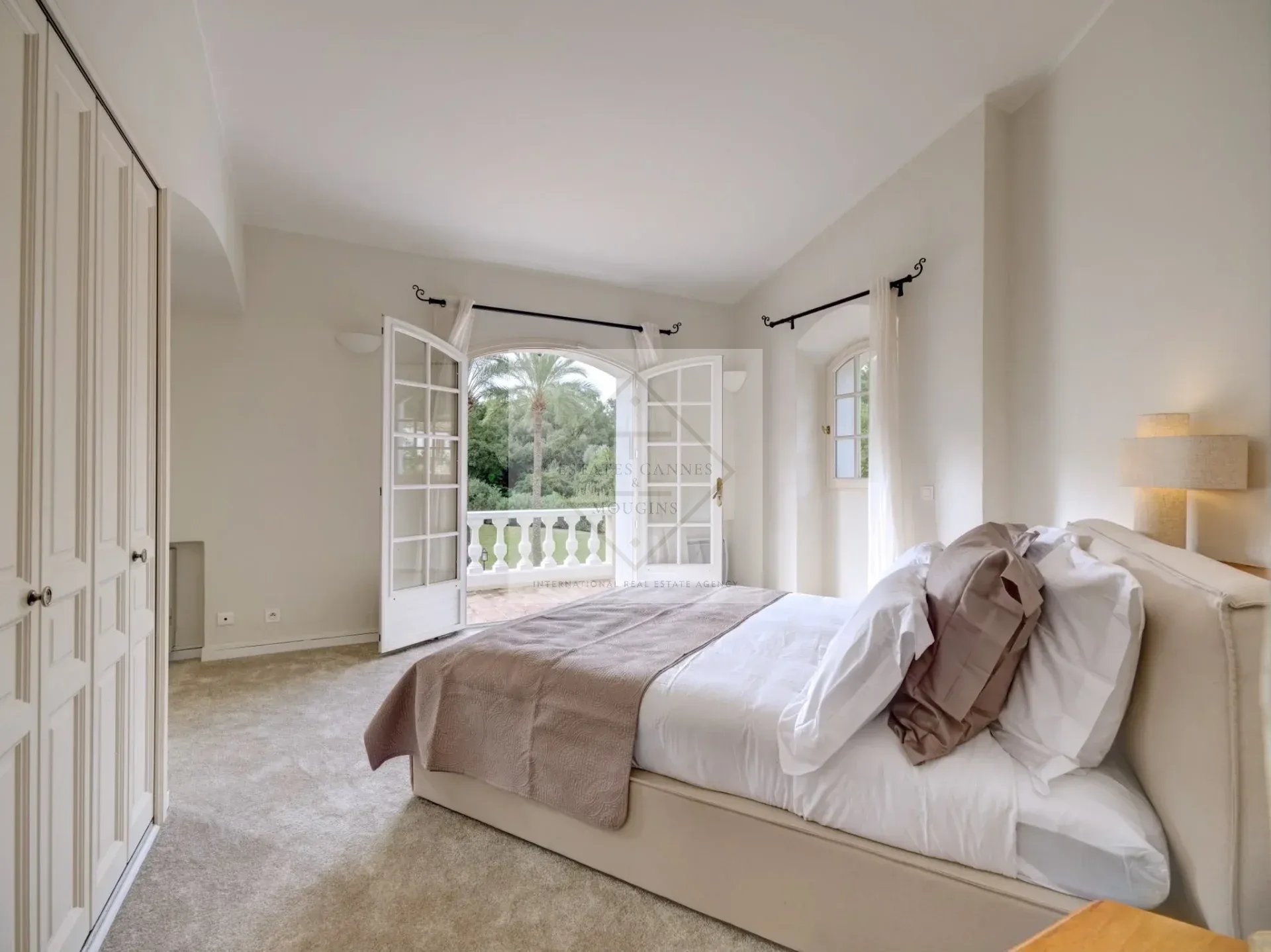 Chambre de villa à Mougins Chambre d'une villa à Mougins avec accès à un balcon et vue sur le jardin.