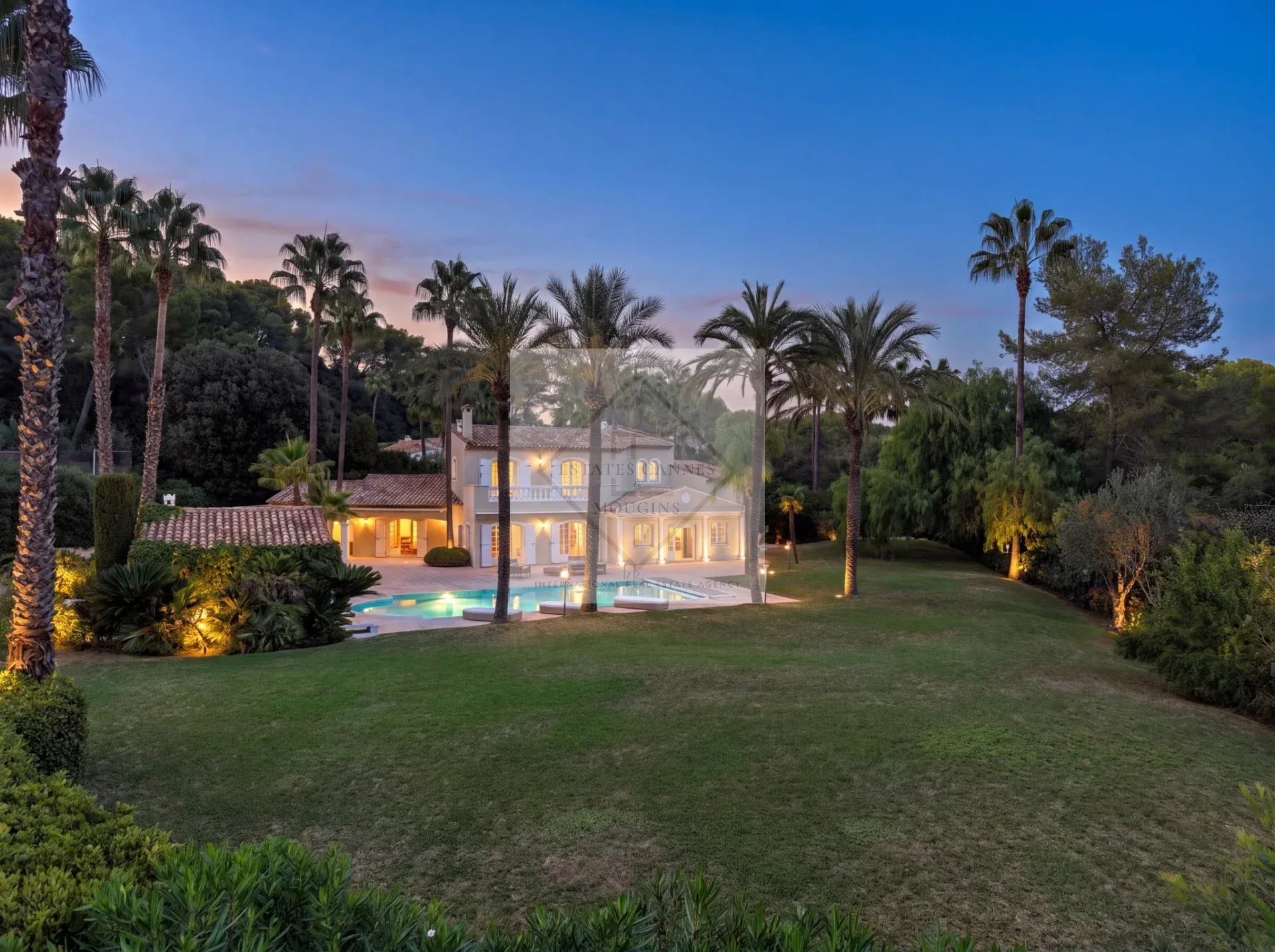 Villa d’exception à Mougins Villa de luxe avec piscine dans un domaine résidentiel à Mougins, entourée de palmiers.