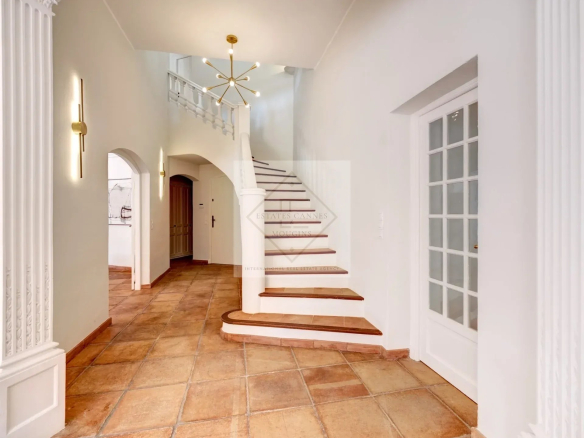 Intérieur d'une villa à Mougins avec un escalier et des murs clairs.
