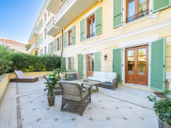 Apartment terrace in Cannes with outdoor furniture and greenery.