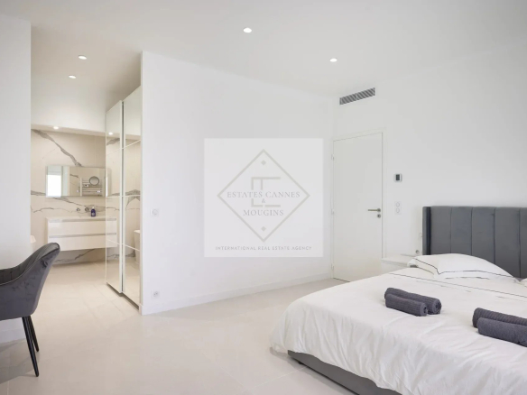 Modern room with double bed, desk and en suite bathroom in a villa in Mougins.