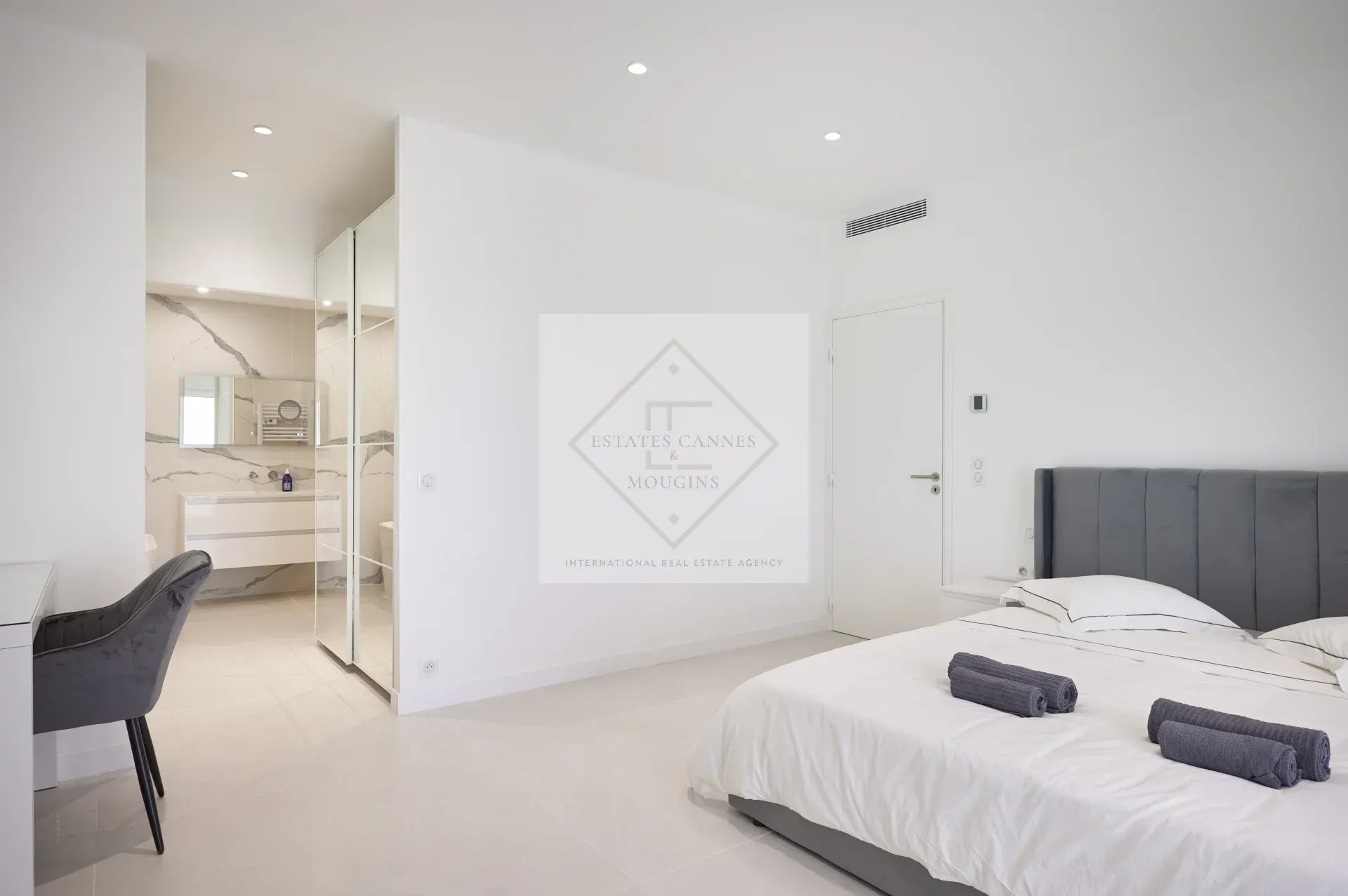 Modern room with double bed, desk and en suite bathroom in a villa in Mougins.