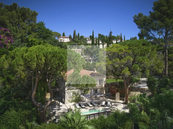 Aerial view of a villa with a swimming pool surrounded by greenery in Mougins.
