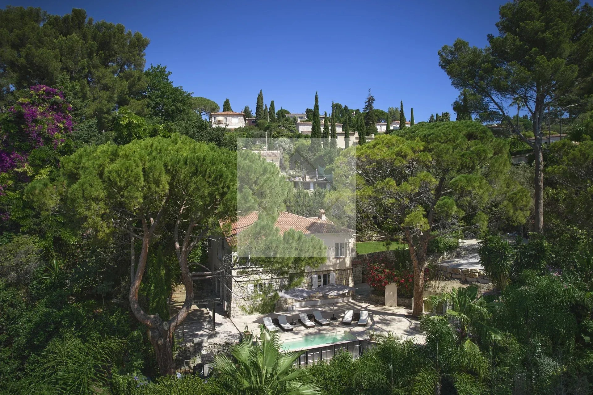 Aerial view of a villa with a swimming pool surrounded by greenery in Mougins.