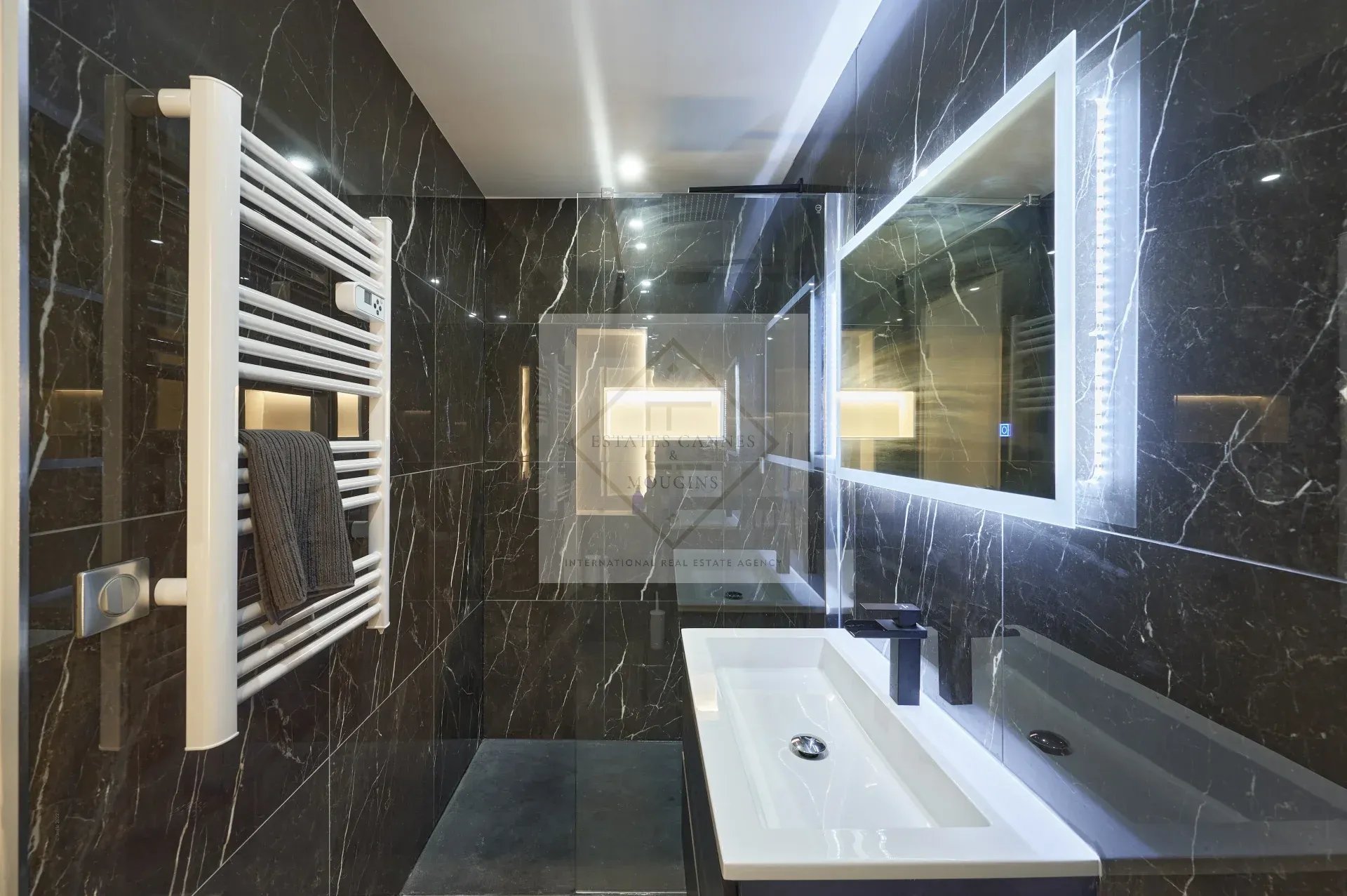 Modern bathroom with black tiles and designer sink.