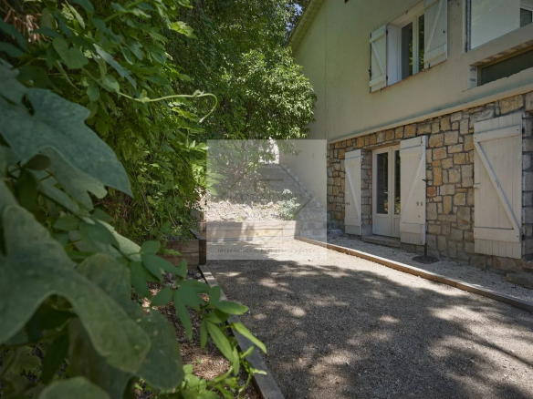 View of a villa with a garden in Mougins, surrounded by greenery.