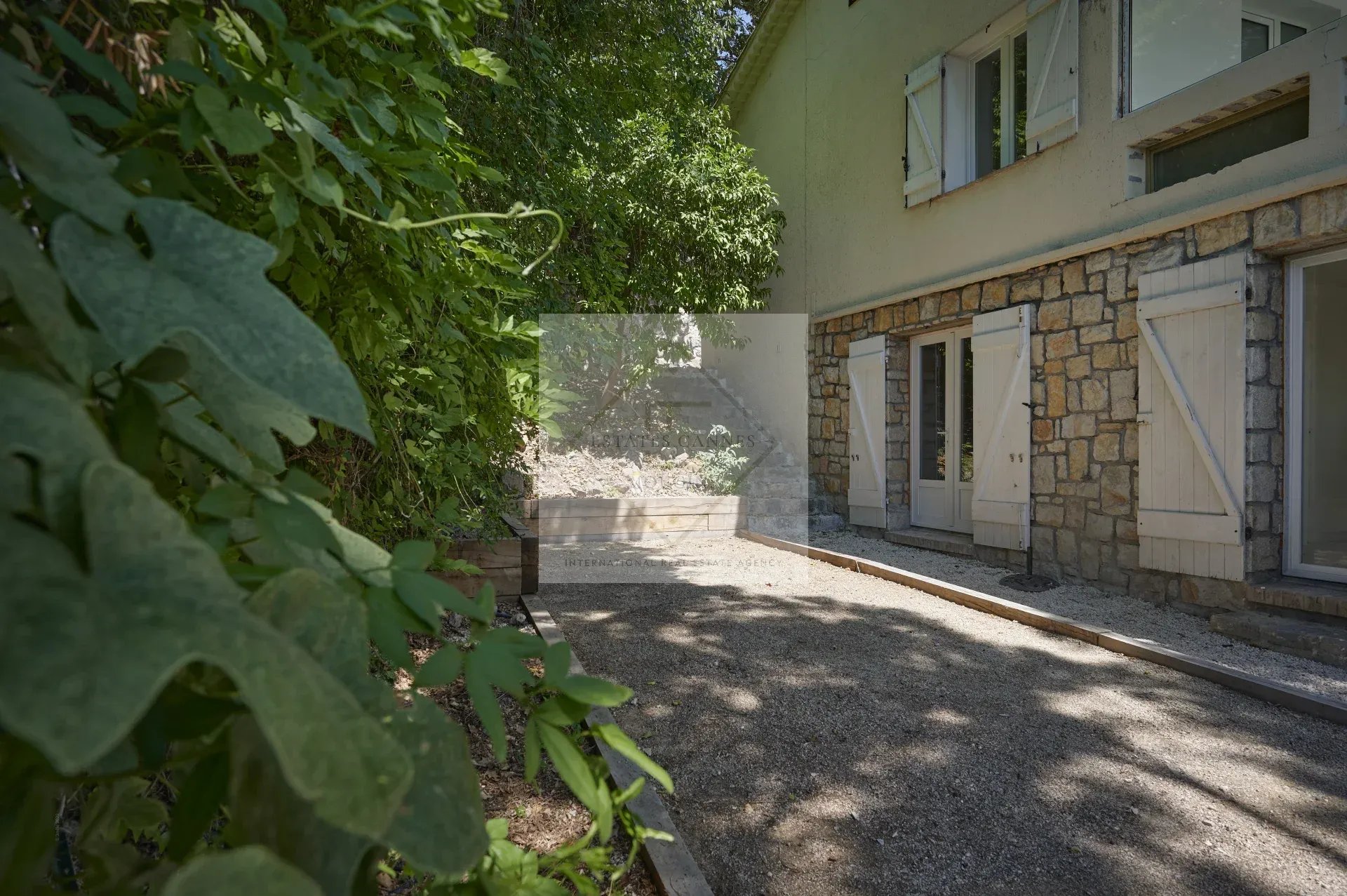 View of a villa with a garden in Mougins, surrounded by greenery.