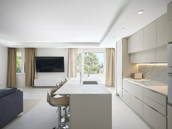 Modern and bright kitchen in a villa in Mougins with central island and living space.