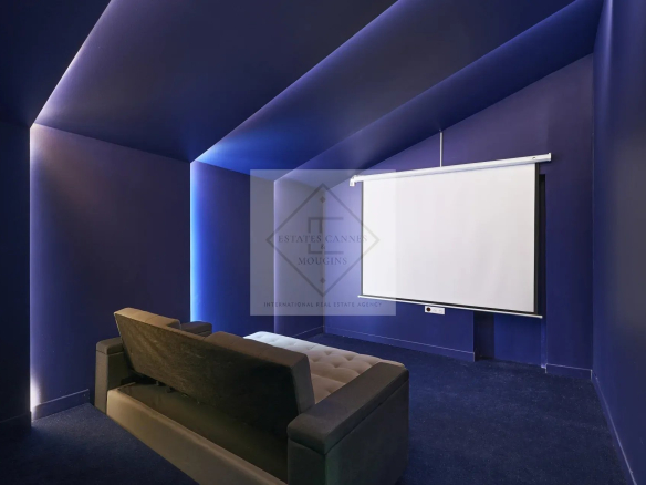 Private cinema room in a villa in Mougins, with a projection screen and a sofa.
