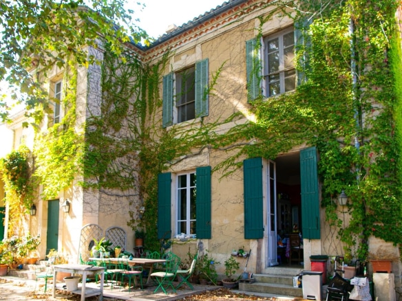 Maison de maître avec façade recouverte de verdure, terrasse et mobilier extérieur, Le Thor.
