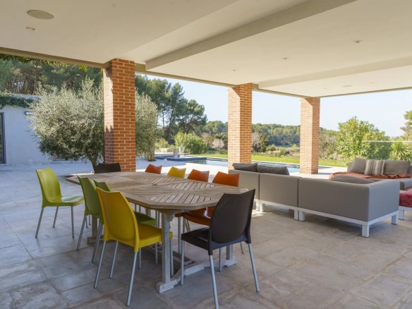 Terrasse d'une villa d'architecte avec mobilier moderne, piscine en arrière-plan, Bouc-Bel-Air.