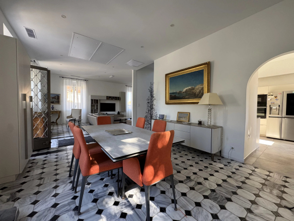 Interior of a renovated country house with a modern dining room and marble floor.