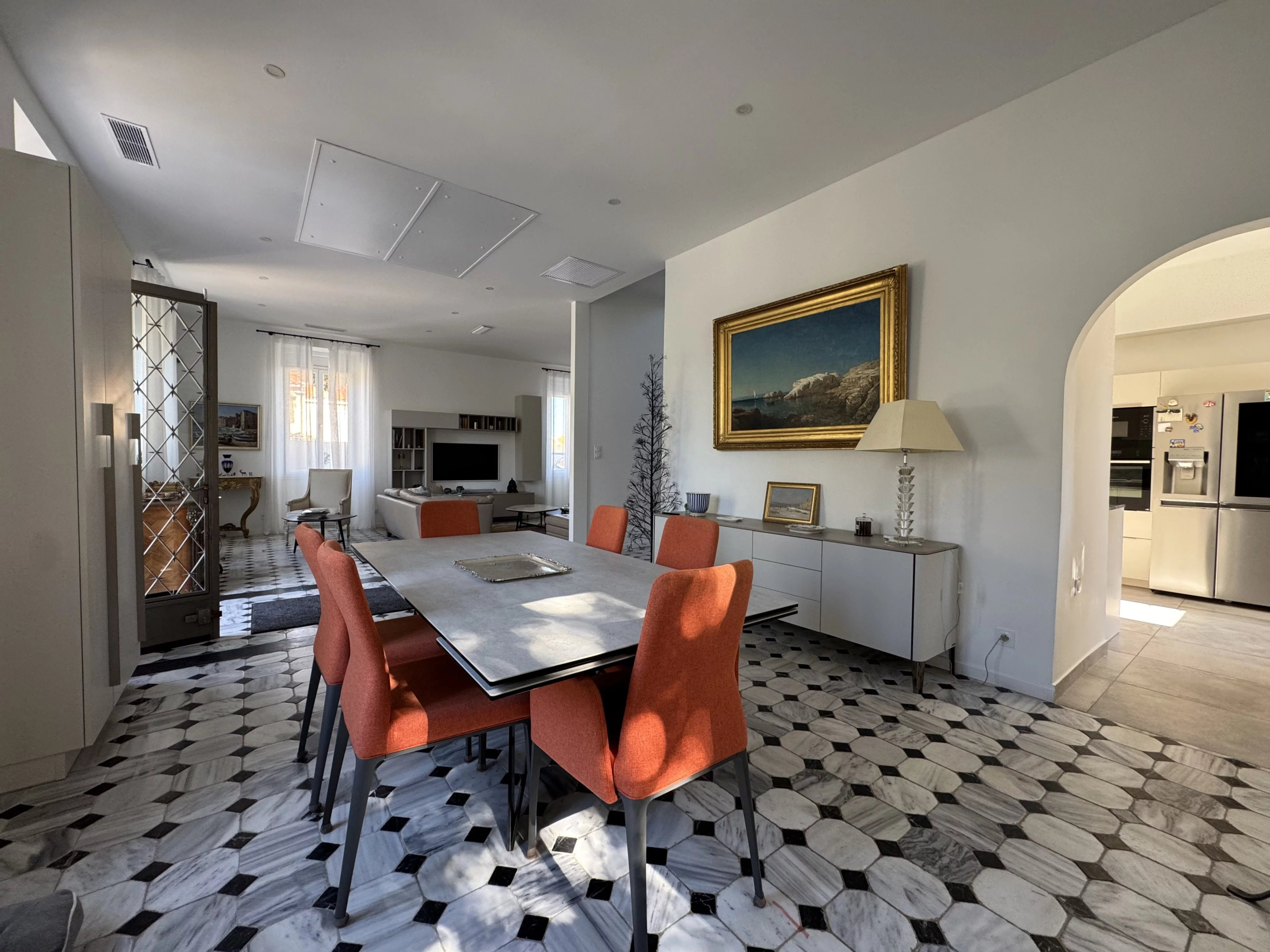 Interior of a renovated country house with a modern dining room and marble floor.