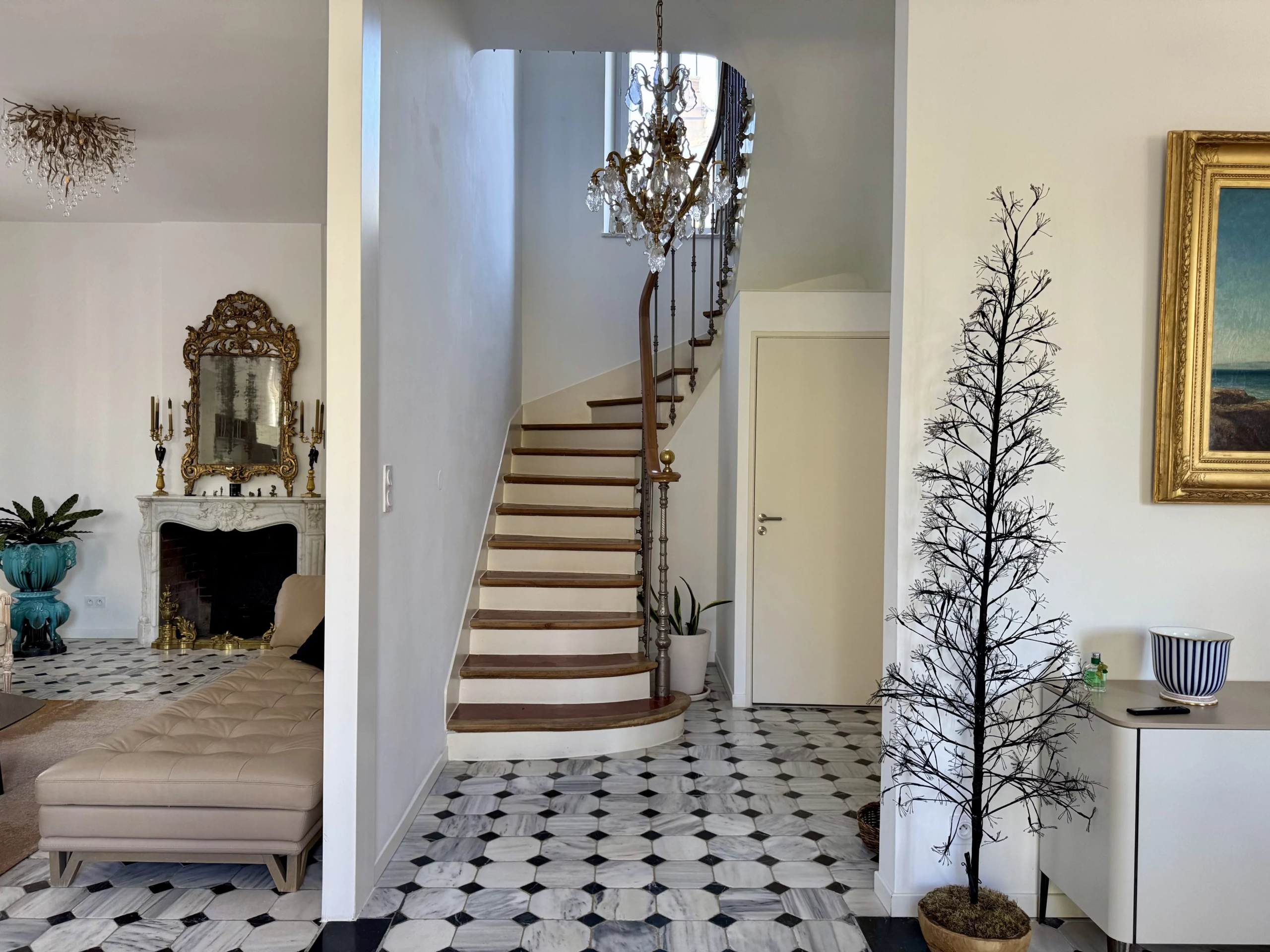 Interior of a renovated bastide in Marseille with a staircase and an elegant living room.