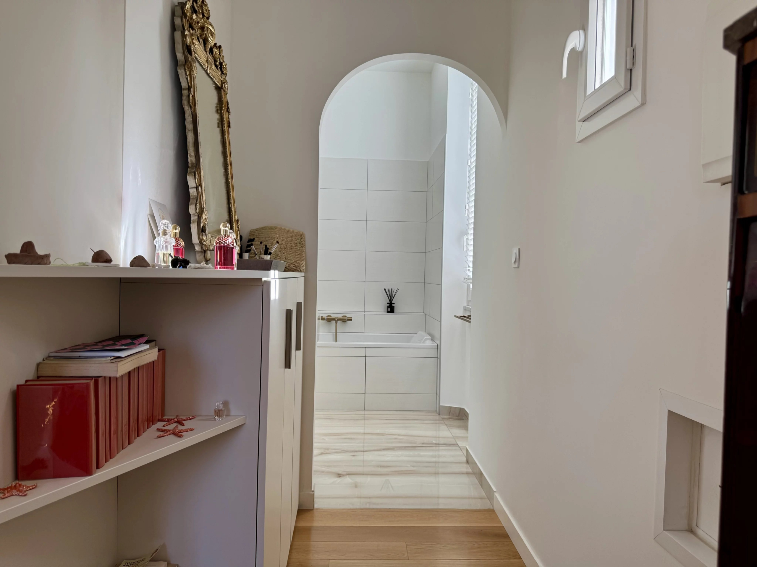 Interior of a renovated country house with a corridor leading to a bright bathroom.