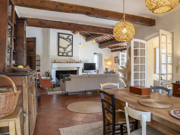 Intérieur d'une propriété avec salon et salle à manger, décor chaleureux et lumineux.
