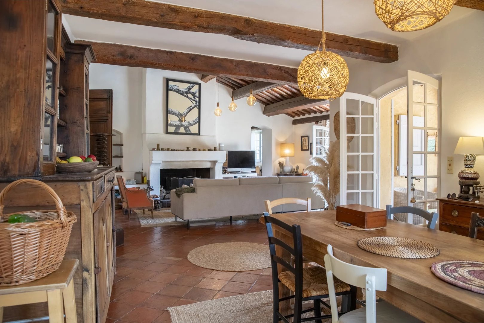 Intérieur d'une propriété avec salon et salle à manger, décor chaleureux et lumineux.