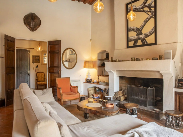 Intérieur d'une propriété avec salon chaleureux, cheminée et décoration méditerranéenne.