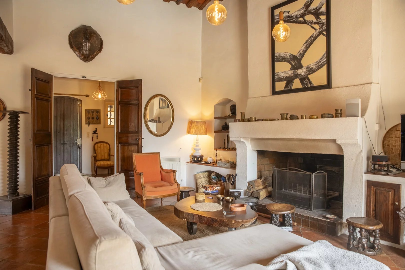 Intérieur d'une propriété avec salon chaleureux, cheminée et décoration méditerranéenne.