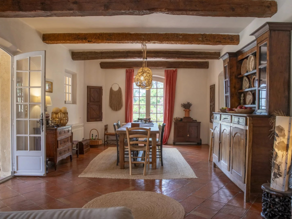 Intérieur d'une propriété avec salle à manger, meubles en bois et décoration méditerranéenne.