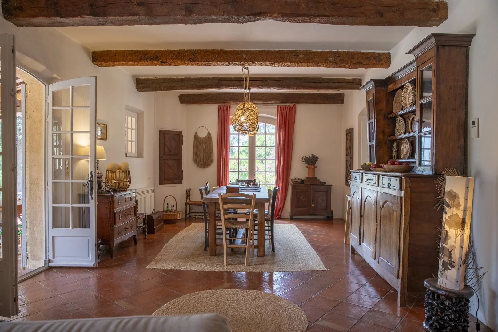 Intérieur d'une propriété avec salle à manger, meubles en bois et décoration méditerranéenne.