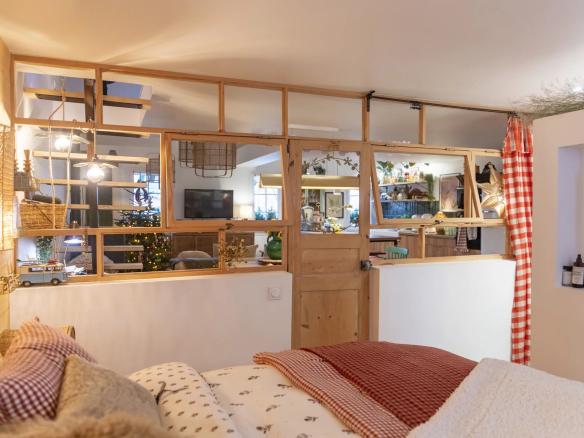 Intérieur d'un immeuble de caractère avec décoration chaleureuse, lit et espace de vie.