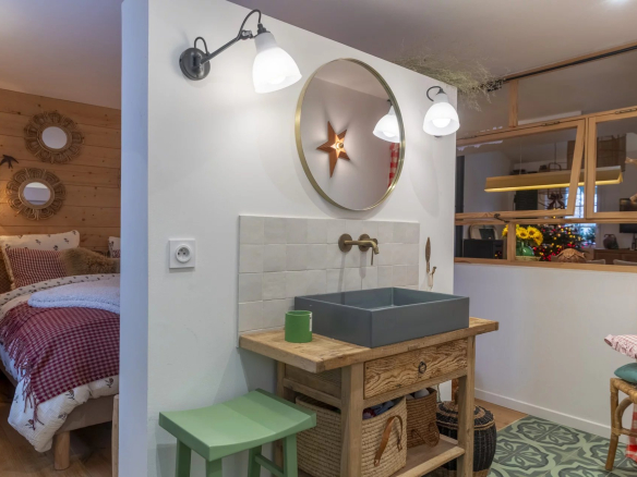 Intérieur d'un immeuble de caractère avec lavabo et miroir, décoré de manière chaleureuse.