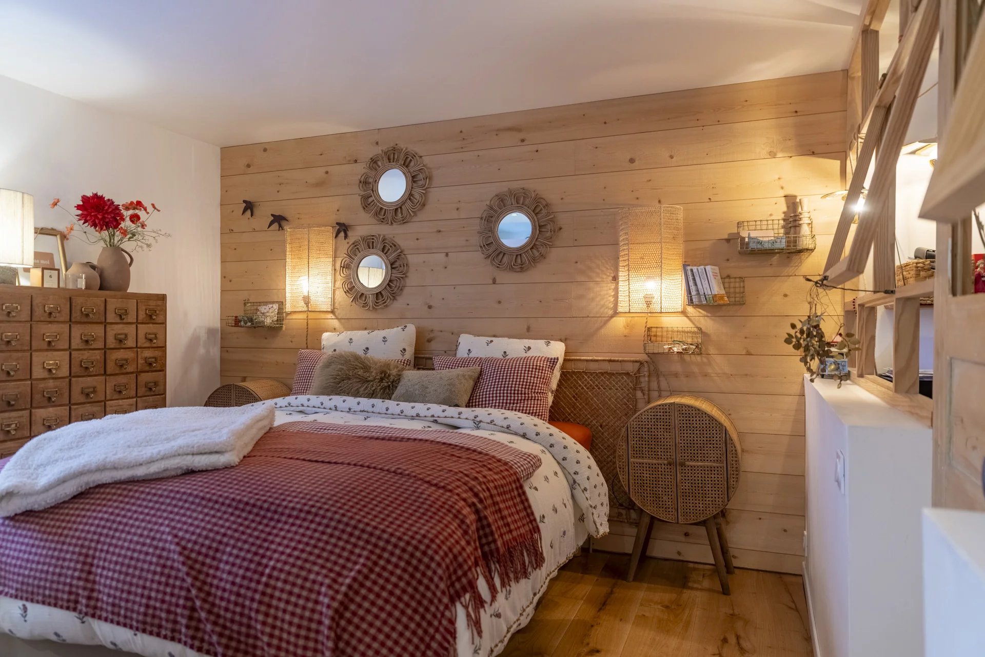 Chambre cosy avec murs en bois, lit confortable et décoration chaleureuse.