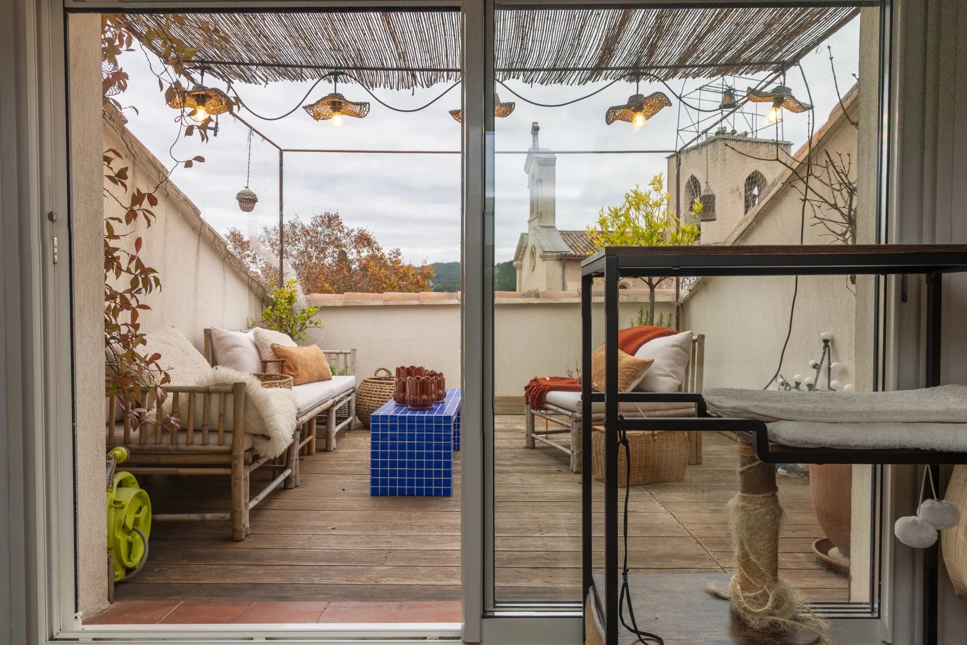 Terrasse d'un immeuble à Saint-Cyr-sur-Mer avec mobilier et décoration cosy.
