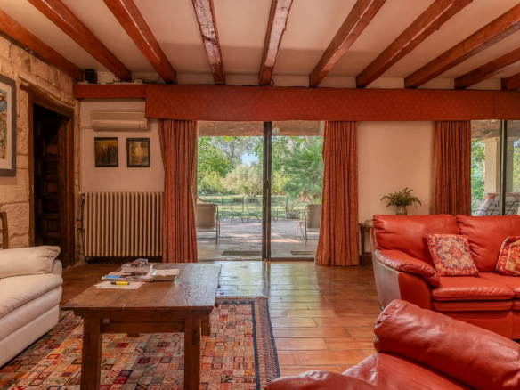 Interior of a property in Fourques with a spacious living room and red sofas, overlooking the garden.