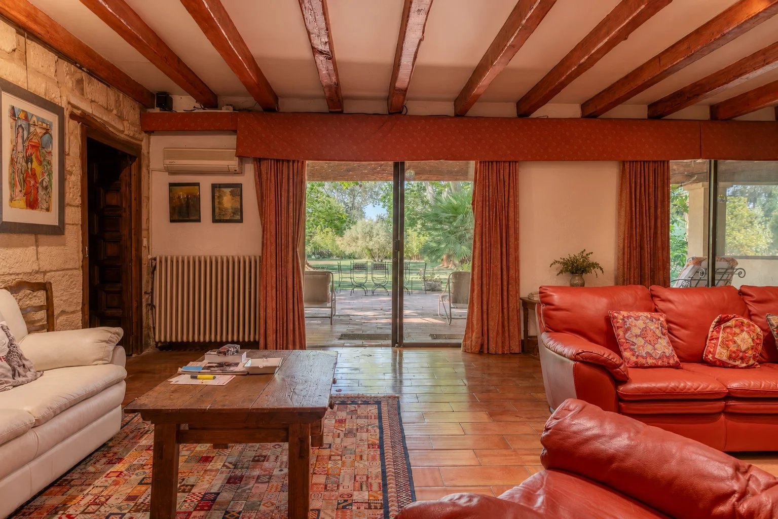 Living room of a property in Fourques Interior of a property in Fourques with a spacious living room and red sofas, overlooking the garden.