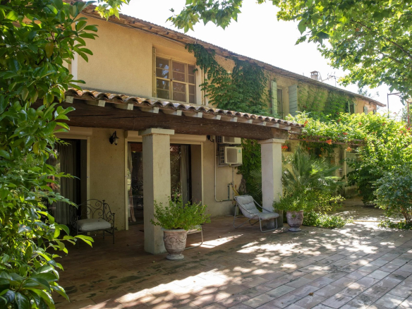 Propriété à Fourques avec jardin, terrasse et végétation luxuriante.
