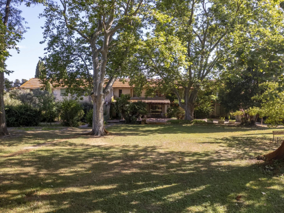 Property with park and trees in Fourques, comprising several accommodations and a swimming pool.